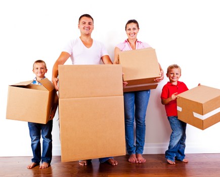 Professional movers carrying furniture through an Islington property