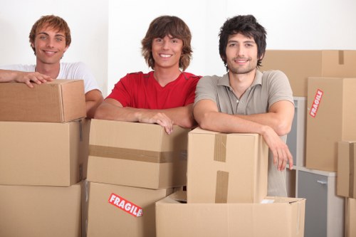 Movers carrying furniture through a flat entrance in Islington