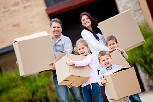 Professional movers carrying furniture through a narrow staircase in Islington
