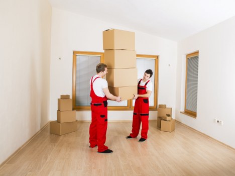 Professional movers handling boxes and furniture in a London flat